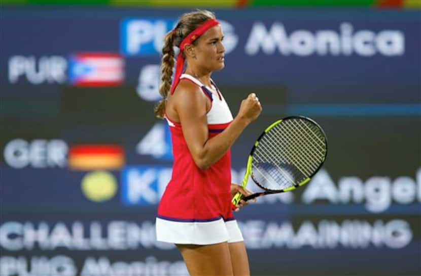 La puertorriqueña Mónica Puig festeja tras ganar un punto ante la alemana Angelique Kerber...