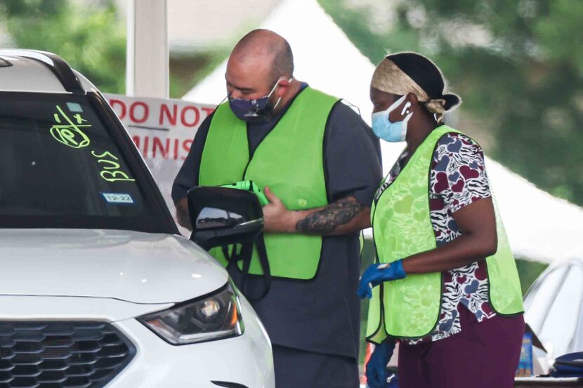 Volunteers attended to a person receiving the COVID-19 vaccine at Fair Park in Dallas in May.