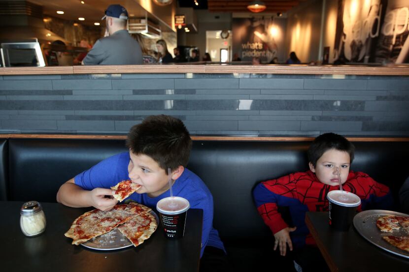 Gabe Clarke (left), 11, and Liam Clarke, 6, eat pizza at Pie Five in Lewisville, Texas on...