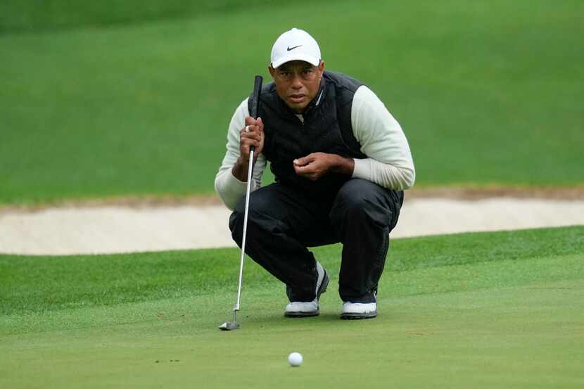 Tiger Woods lines up a putt on the 16th hole during the weather delayed second round of the...