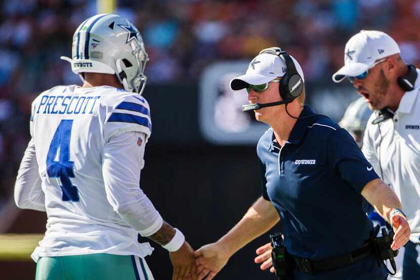 Dallas Cowboys quarterback Dak Prescott (4) high fives head coach Jason Garrett after a...