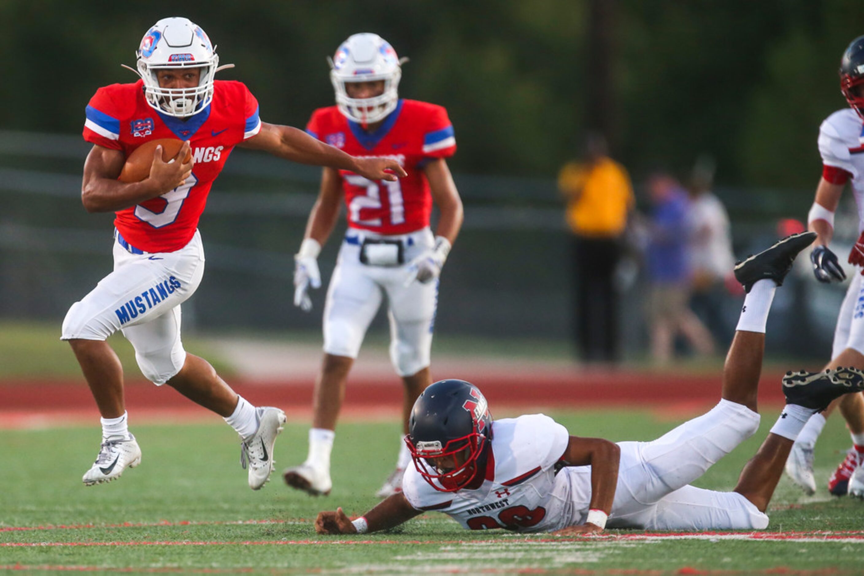 Grapevine running back Caled Texada (3) carries the ball past Northwest's Jacob Kirk (20)...