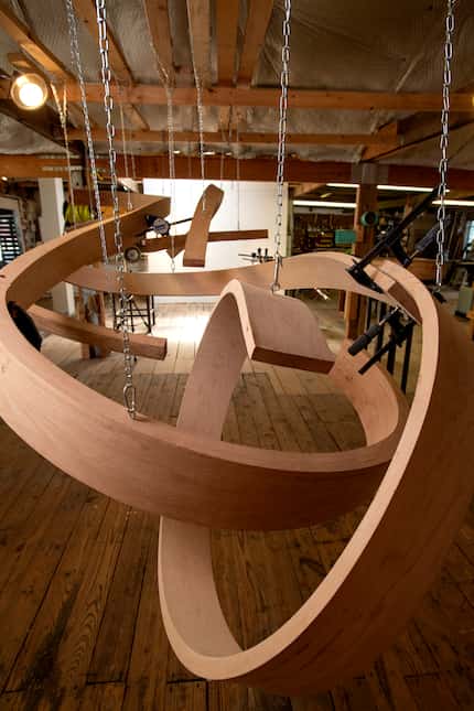 One of artist Rick Maxwell's unfinished curved wooden sculptures hangs in his studio.