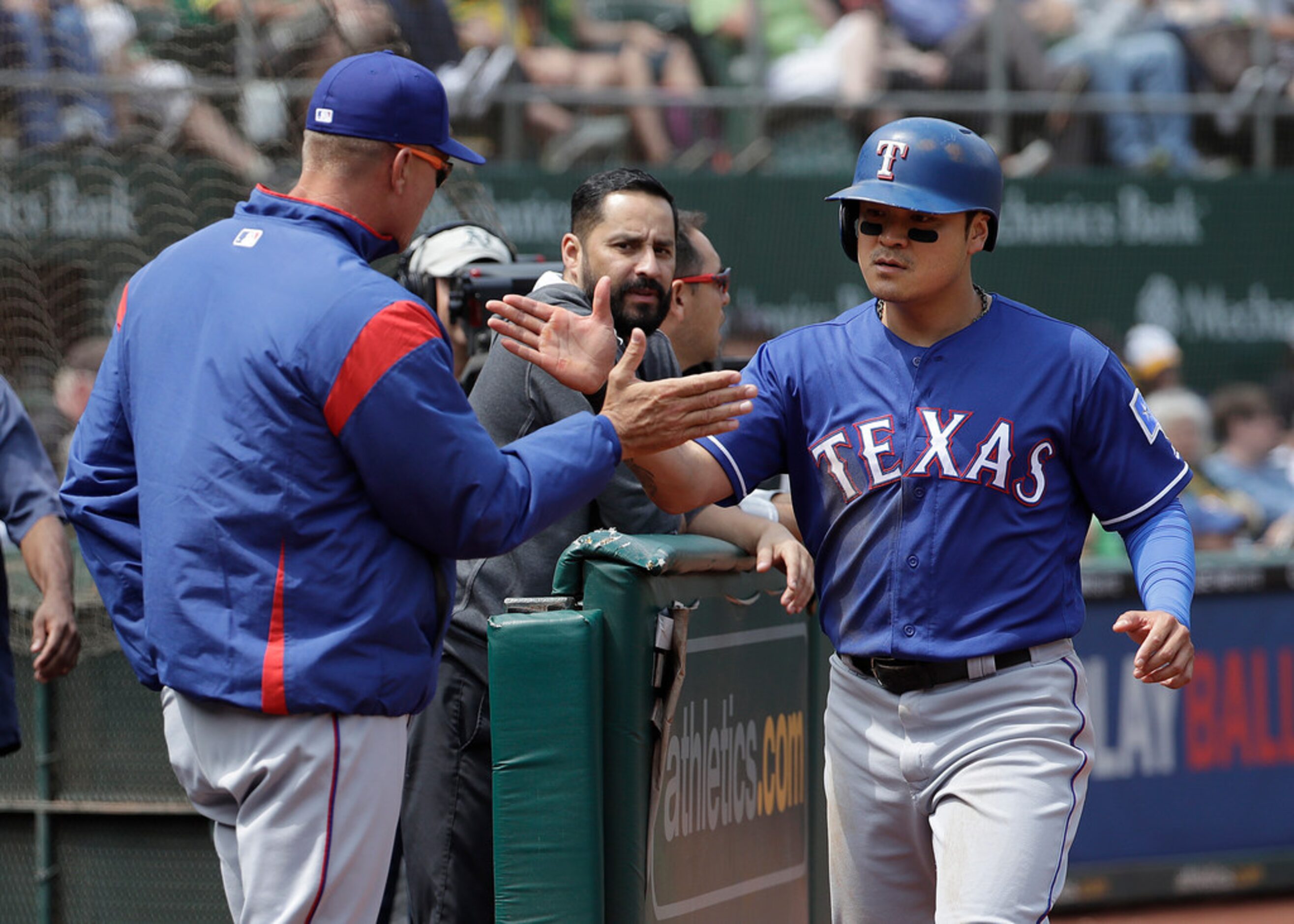 Texas Rangers' Shin-Soo Choo, right, is congratulated after scoring against the Oakland...