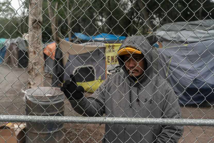 Un hombre que pide asilo a Estados Unidos espera una oportunidad en un campamento para...