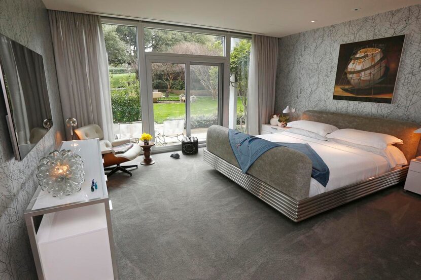 
Floor-to-ceiling windows in the master bedroom offer a view of the property’s 2-acre...