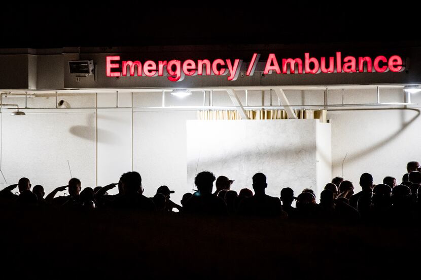 California Highway Patrol Officers gather outside the emergency room entrance to the...