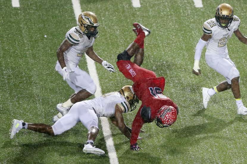 Cedar Hill's Kolbi McGary (31) is flipped after getting tackled by DeSoto's Caleb Abrom (10)...