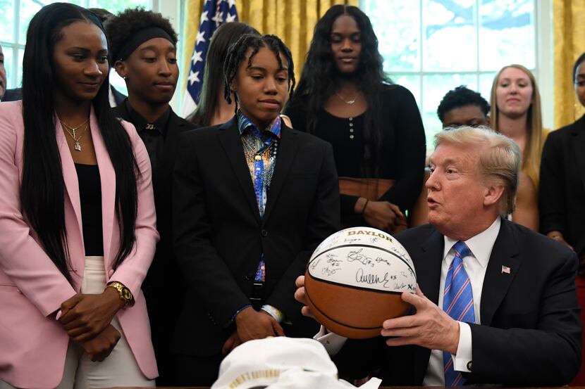 President Donald Trump holds a basketball as he speaks as he welcomes members of the Baylor...