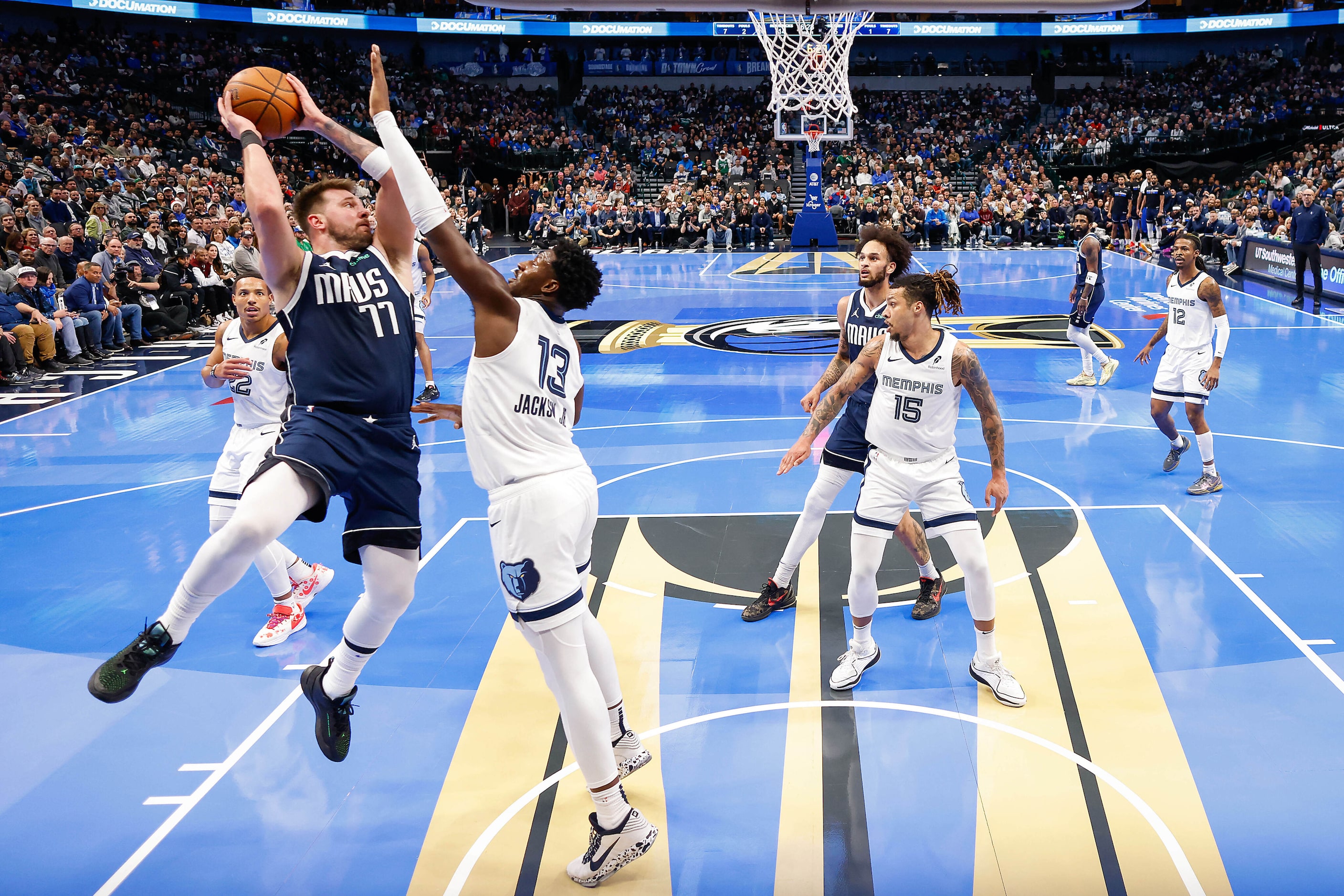 Dallas Mavericks guard Luka Doncic (77) passes around Memphis Grizzlies forward Jaren...