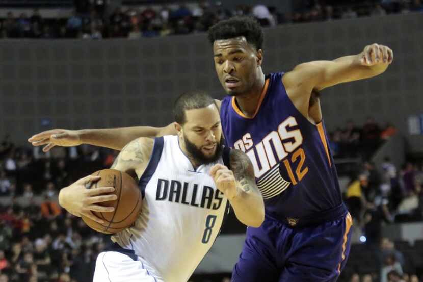 Dallas Mavericks Wesley Matthews (L) vies for the ball with Devin Booker (R) of the Phoenix...