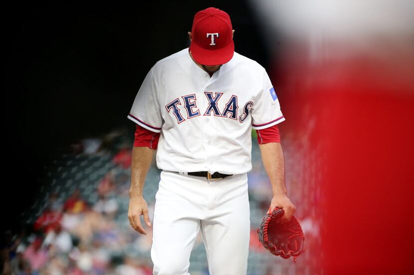 Texas Rangers starting pitcher Martin Perez (33) walks off the mound after the first inning...