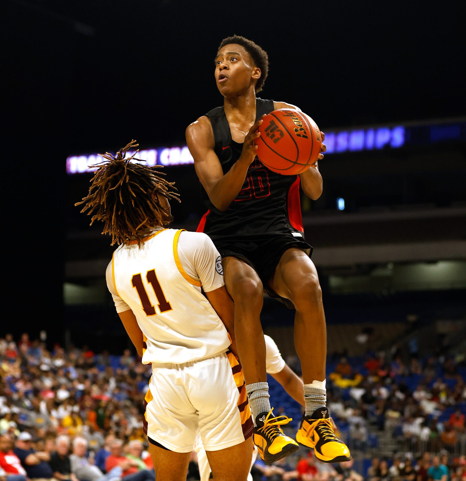 Lake Highlands Tre Johnson (20) is fouled by Beaumont United Kayde Dotson (11) on his drive...