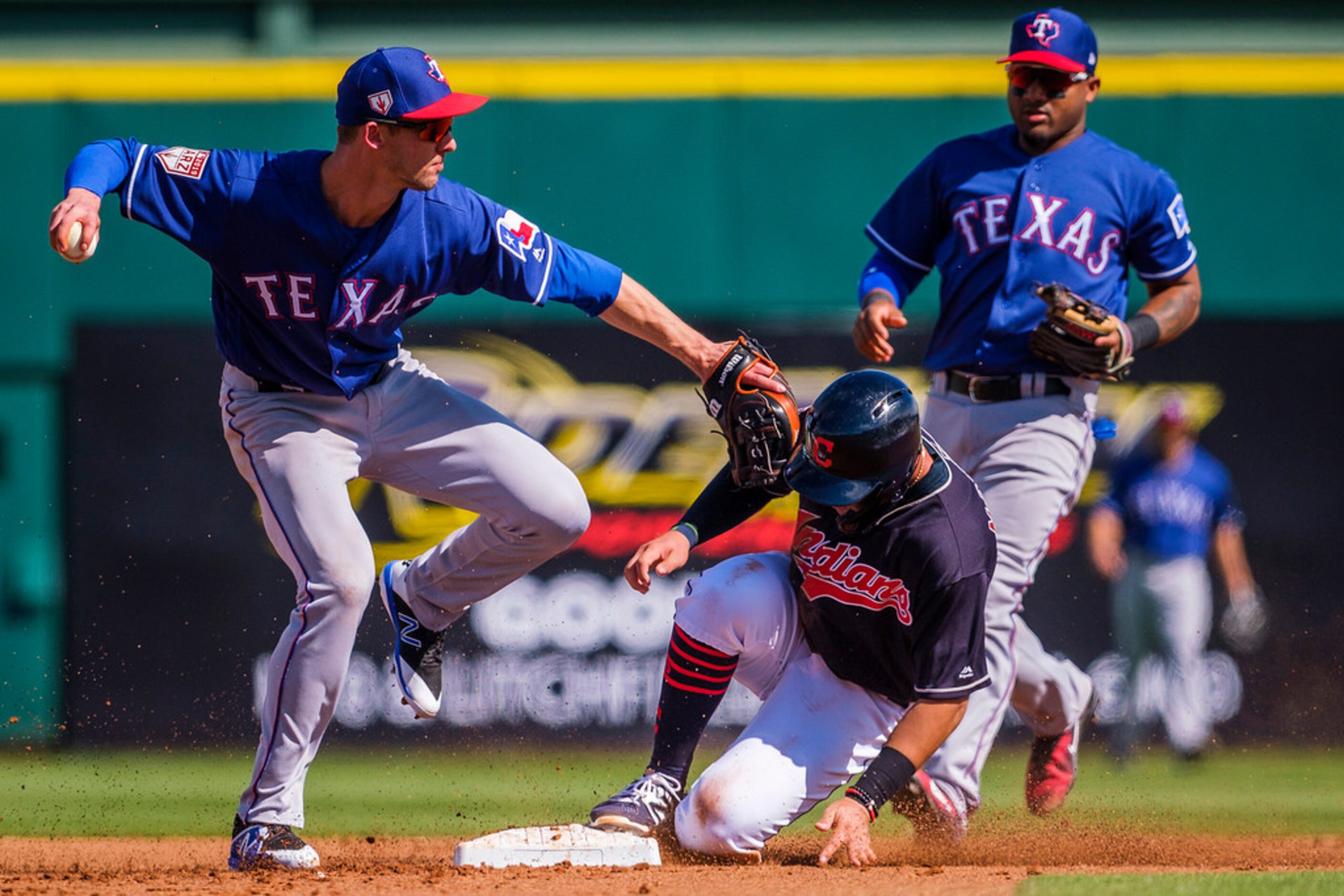 Texas Rangers infielder Eli White makes the relay over Cleveland Indians pinch runner Mark...