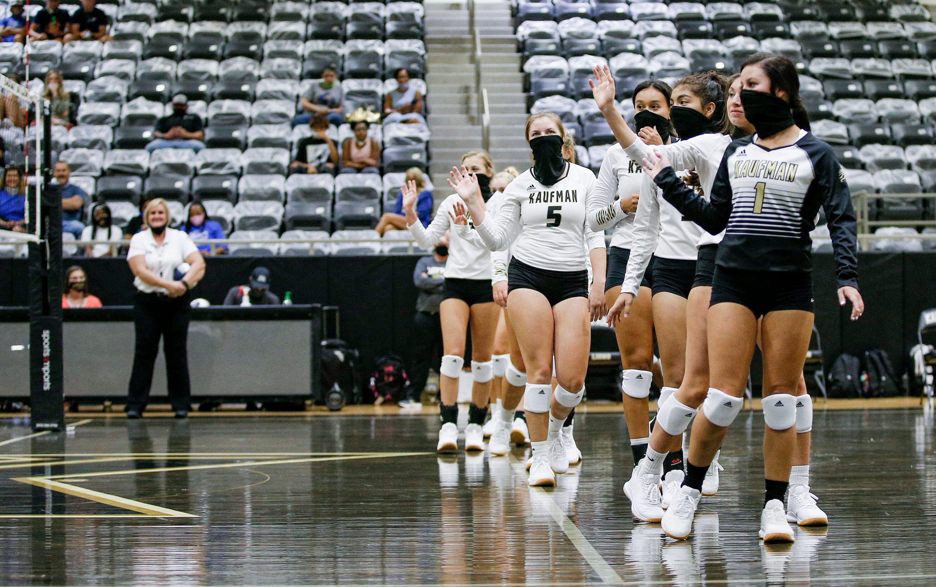 The Kaufman varsity volleyball team waves to the Lindale team in lieu of the traditional...