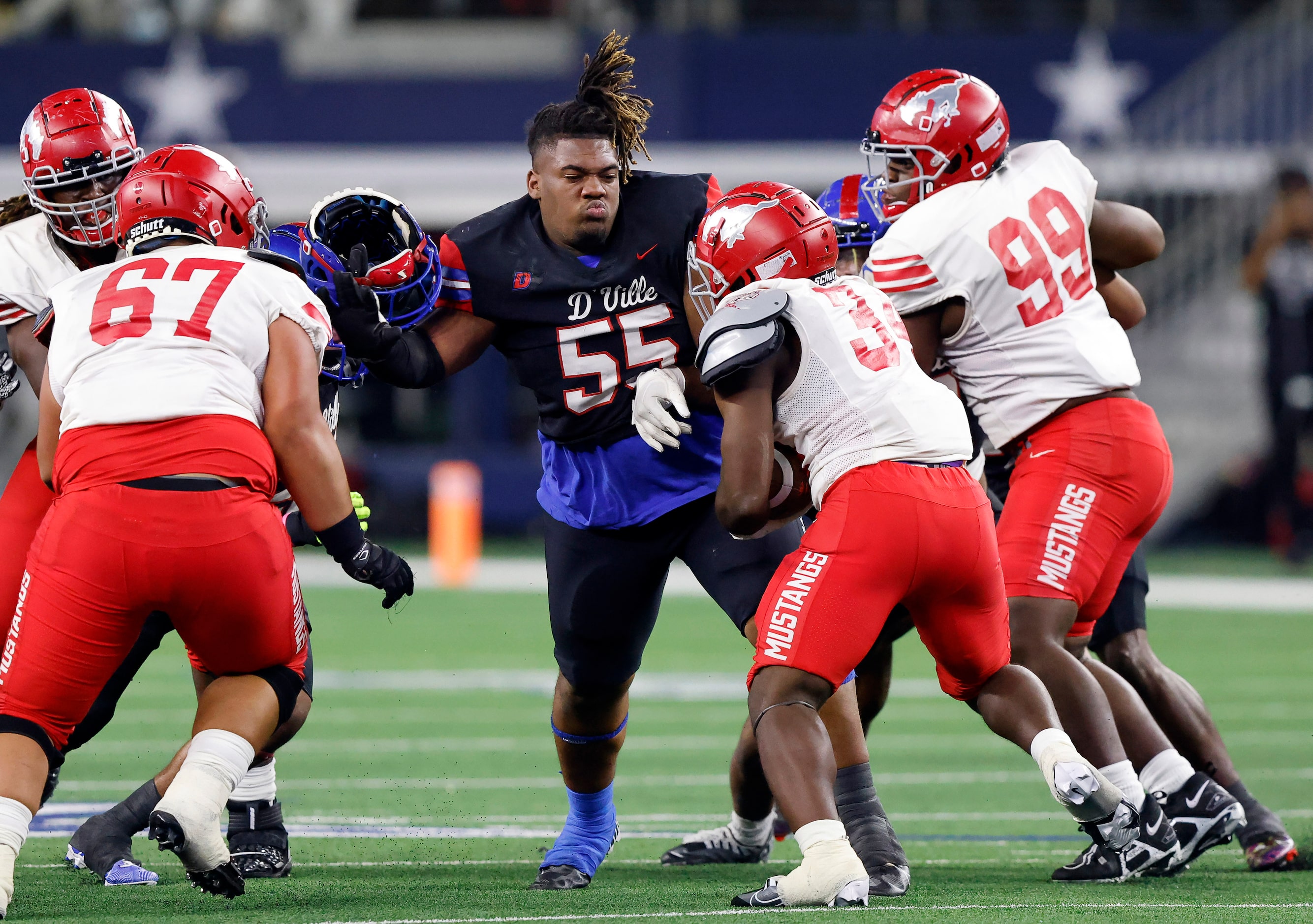 Despite losing his helmet, Duncanville defensive lineman Jabreohn Peters (55) looks to...