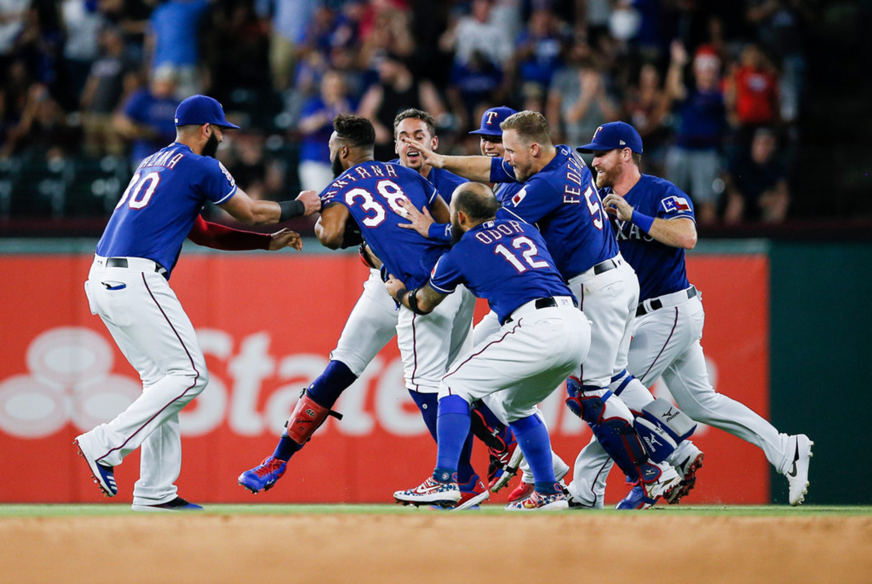 Texas Rangers' Danny Santana (38) is congratulated by teammates after hitting a walkoff...