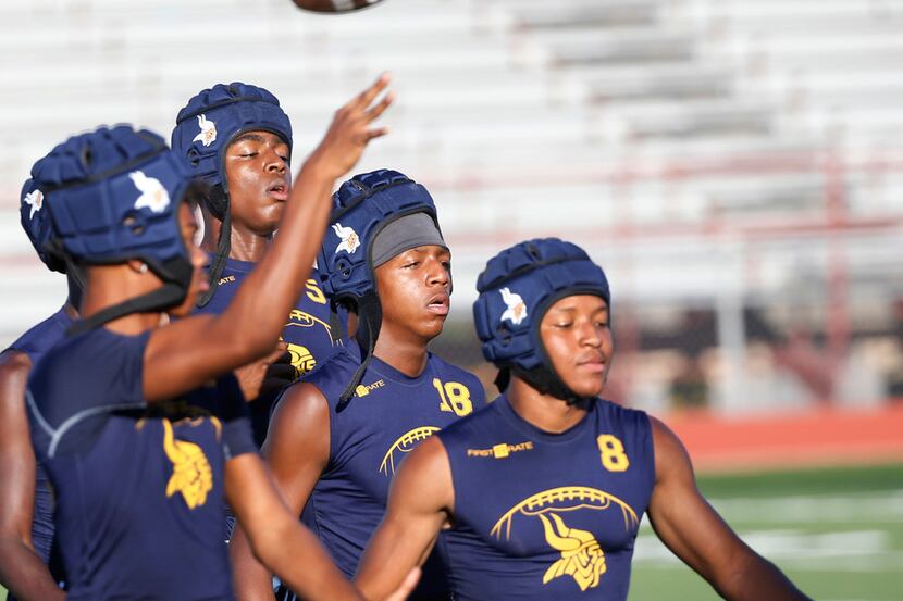 The Arlington Lamar High School 7-on-7 football team wears all-soft shell helmets during...