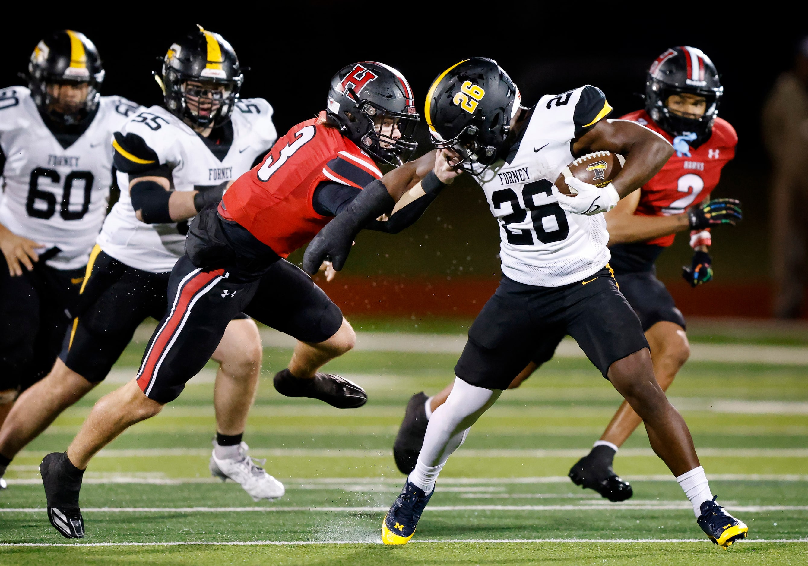 Forney running back Javian Osborne (26) has his head spun backwards by Rockwall-Heath safety...