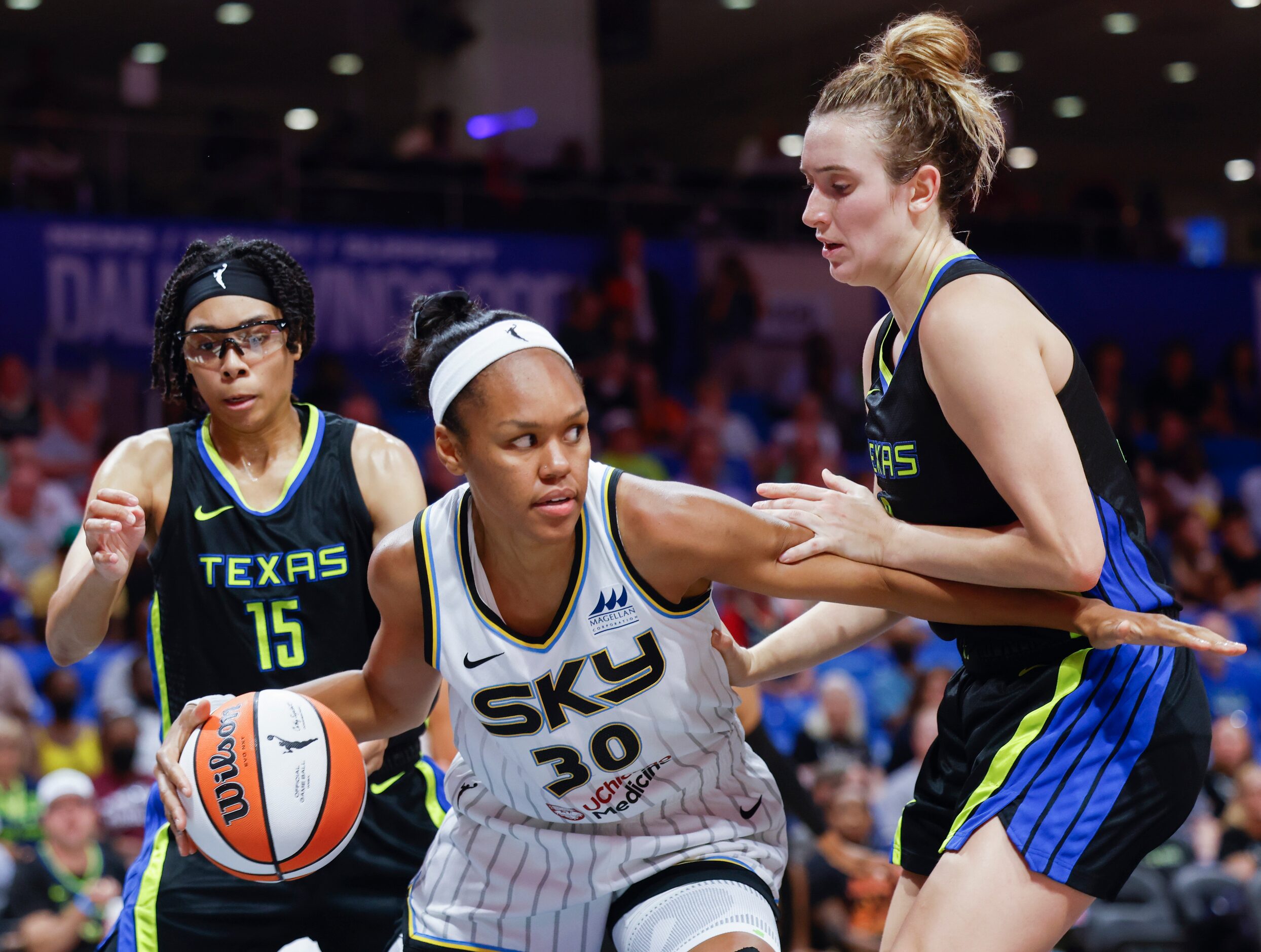 Chicago Sky forward Azura Stevens, center, looks to pass between Dallas Wings guard Marina...