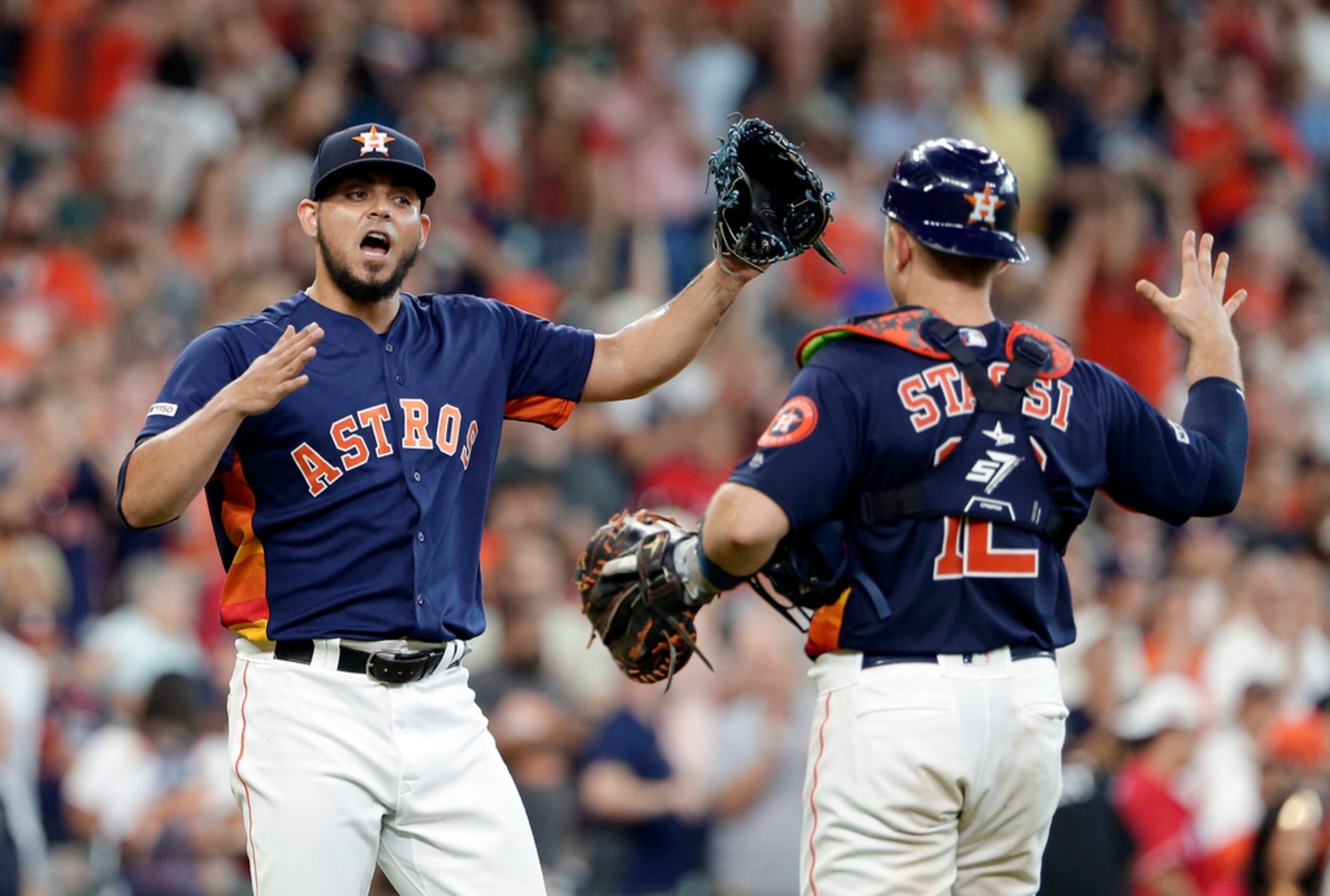 Houston Astros closing pitcher Roberto Osuna, left, and catcher Max Stassi, right, celebrate...