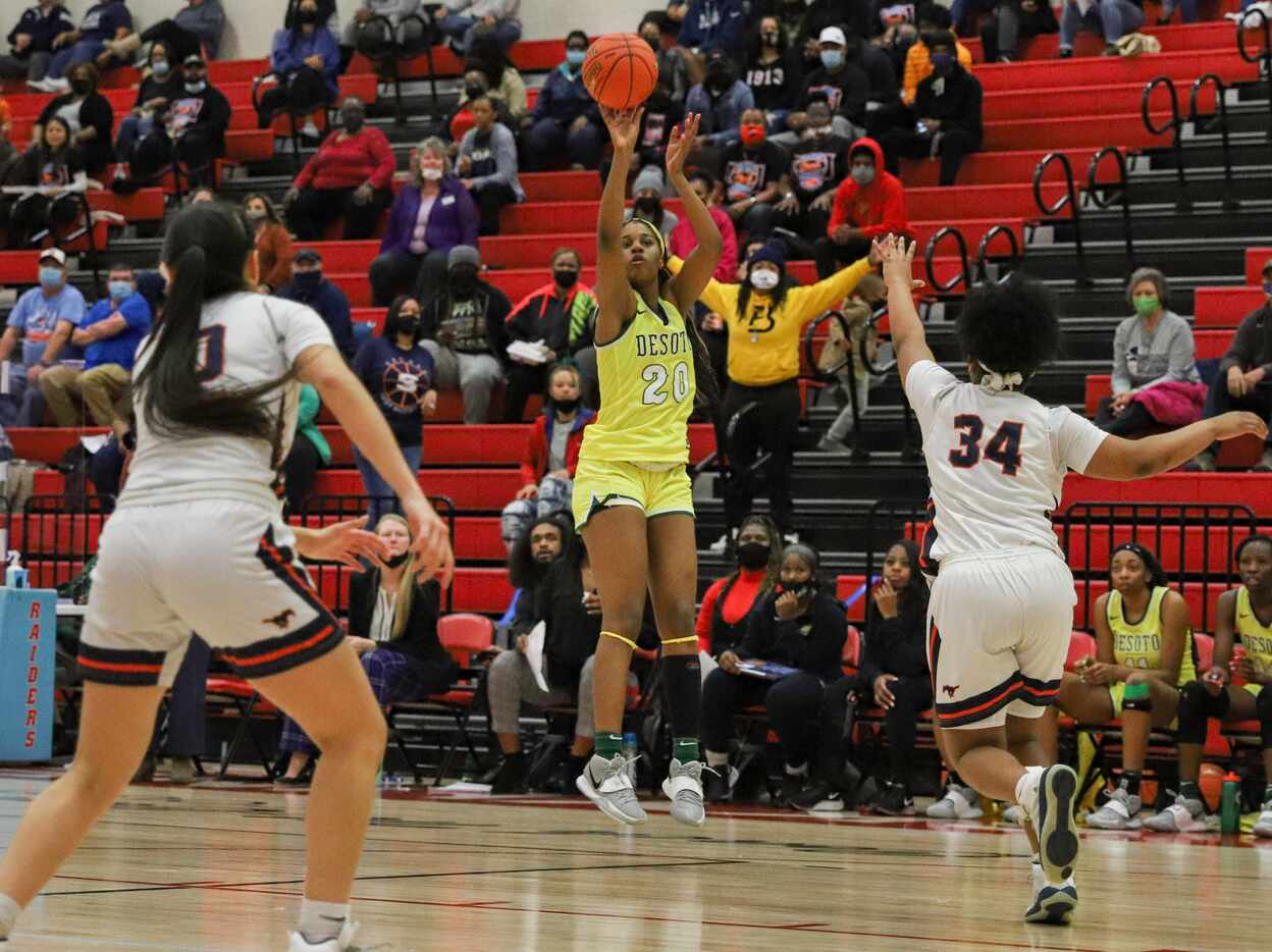 DeSoto’s Ayanna Thompson (20) shoots a three-point shot over Sachse’s Neenah George (34)...