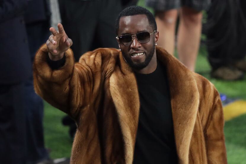 Fresh dressed: Rapper Sean "Diddy" Combs waves to the crowd during warm-ups prior to Super...