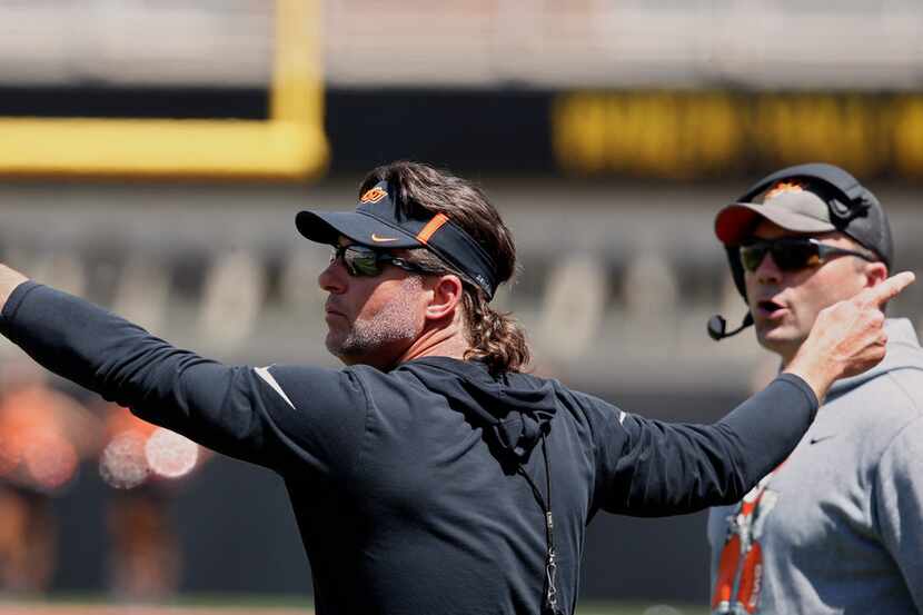 Oklahoma State head coach Mike Gundy gestures to his team during an NCAA college football...