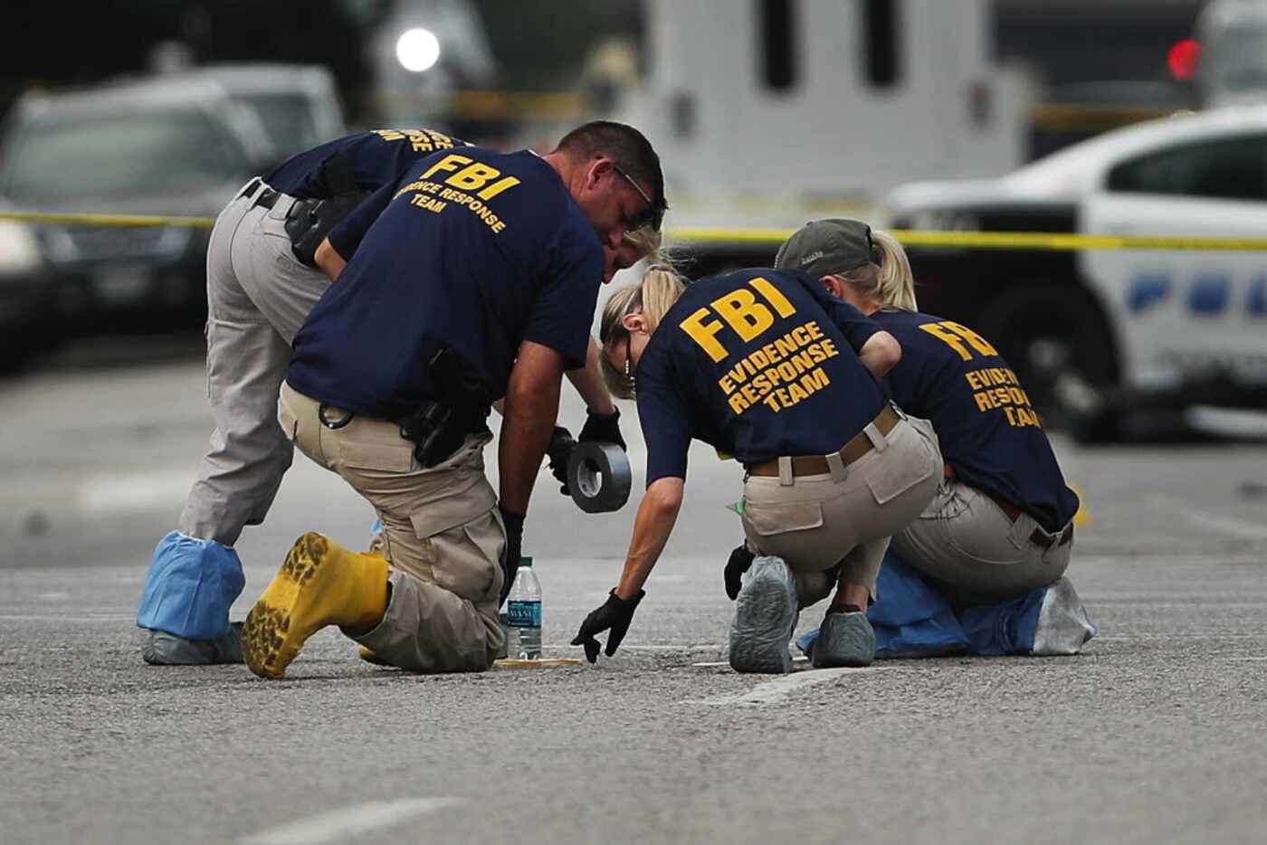 DALLAS, TX - JULY 09:  Members of an FBI evidence response team search an area that is still...