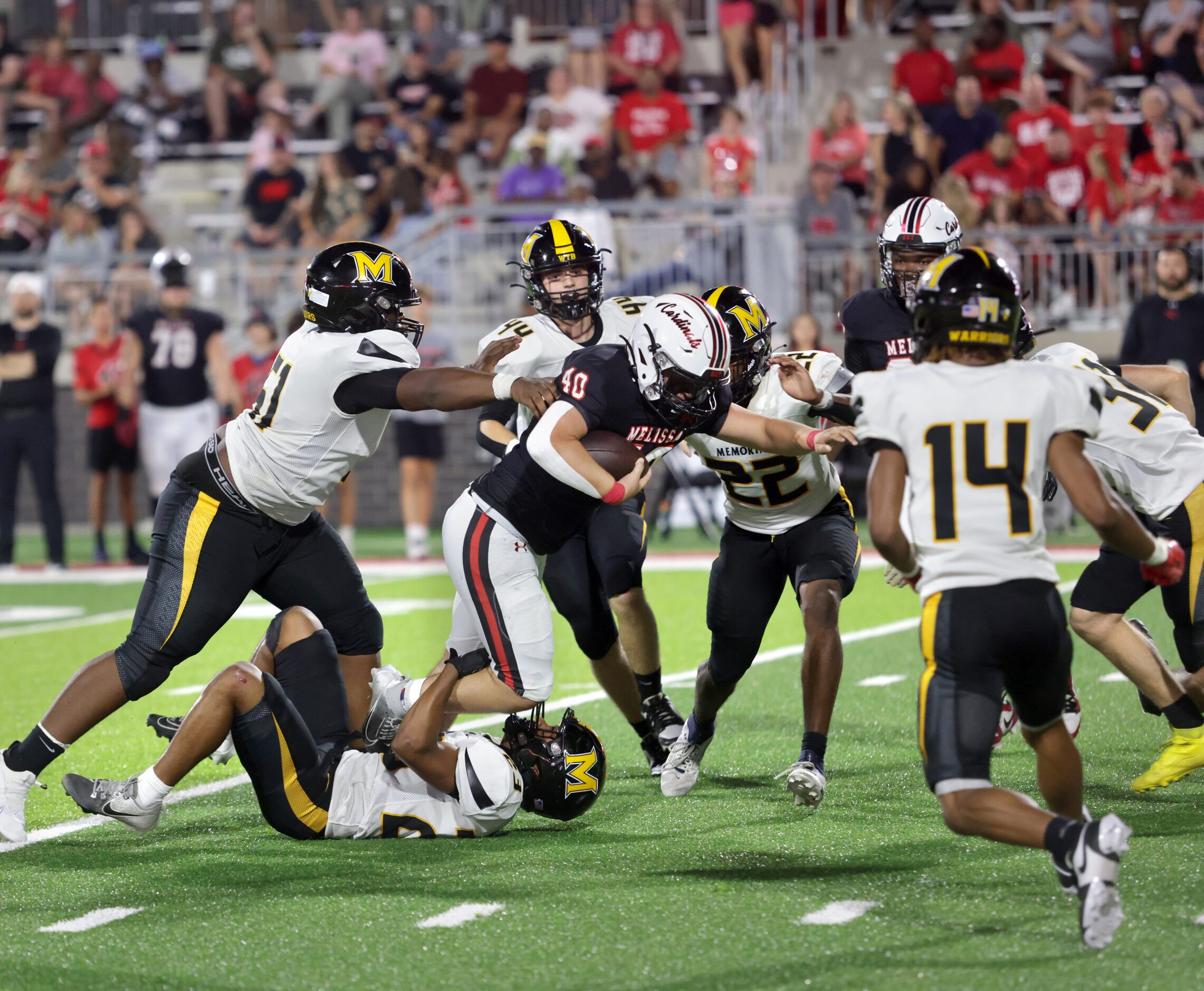 Melissa player #40 Billy Heid becomes surrounded by Memorial players during the Frisco...