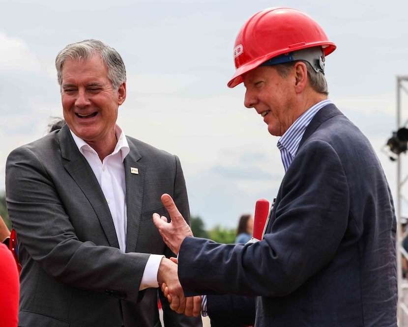 Plano Mayor John Muns and Central Market president Stephen Butt shake hands at the...