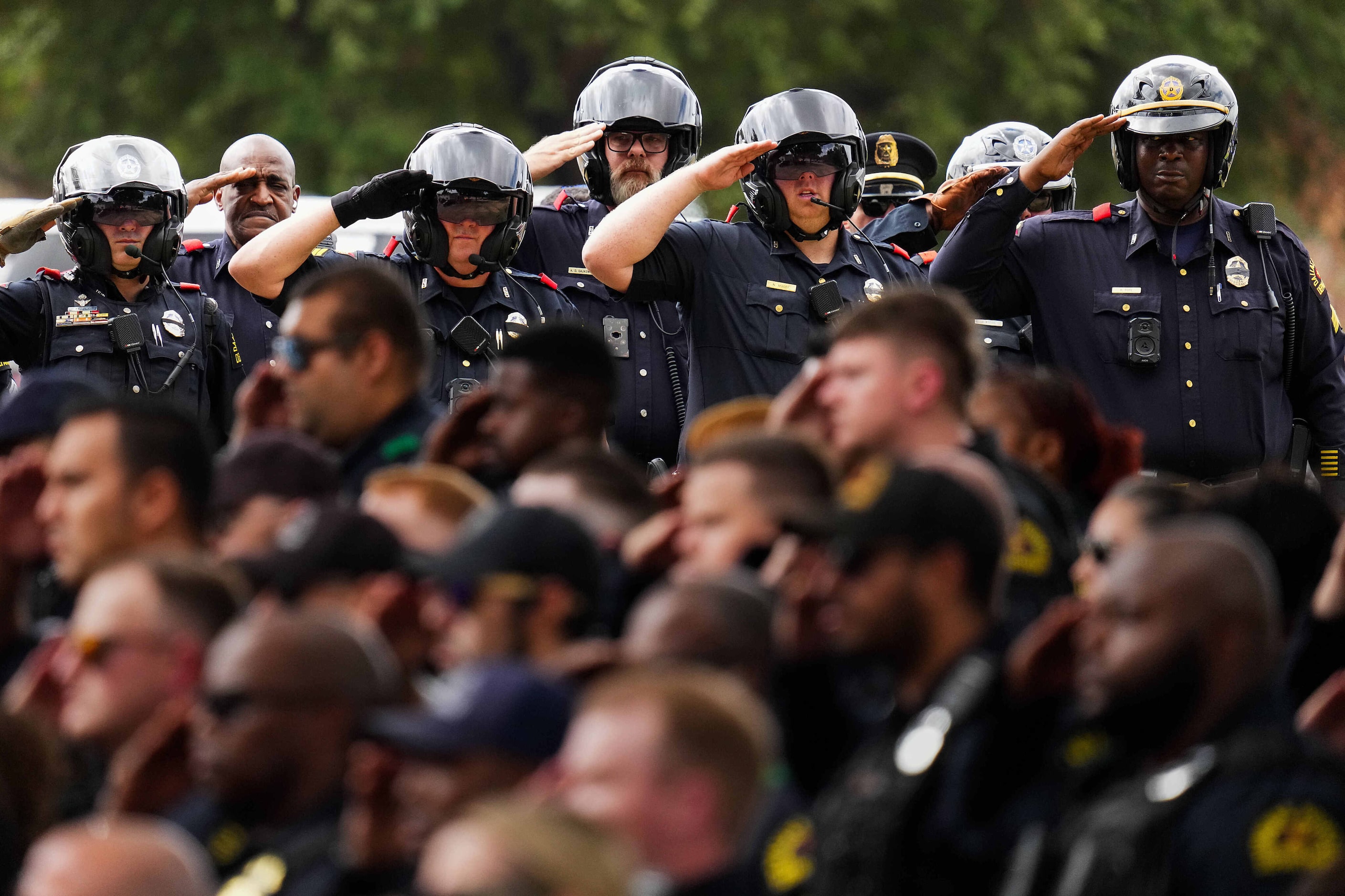 Dallas police salute at Restland Funeral Home as fallen officer Darron Burks is transferred...