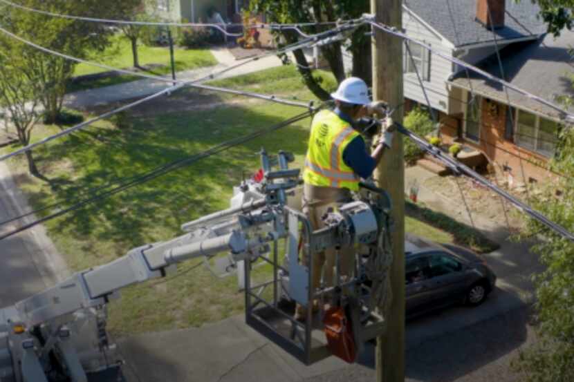An AT&T technician installs fiber optic lines.