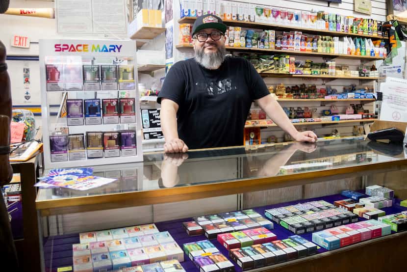 Area manager Javi Villarreal poses behind the disposable nicotine vapes on sale at Gas Pipe...