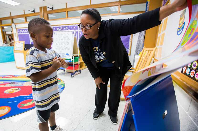 Marlon Whyte, an incoming kindergarten student, looked at reading material with teacher...