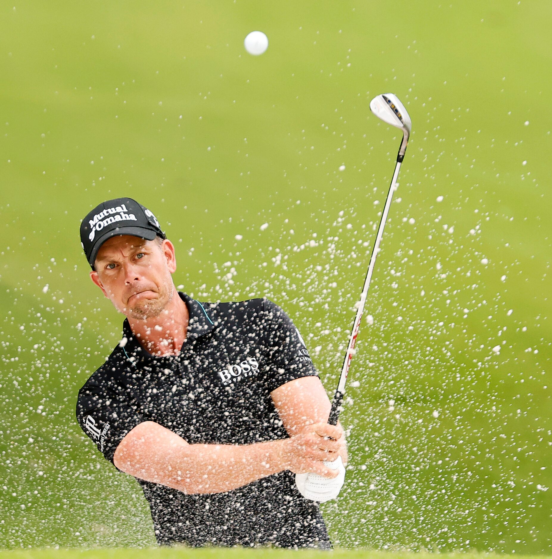 Professional golfer Henrik Stenson hits out of the green side trap on No. 5 during round two...