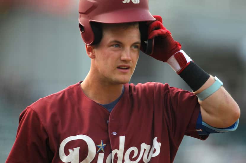 Frisco RoughRiders 3rd baseman Josh Jung (18) puts on his batting helmet as he heads to the...