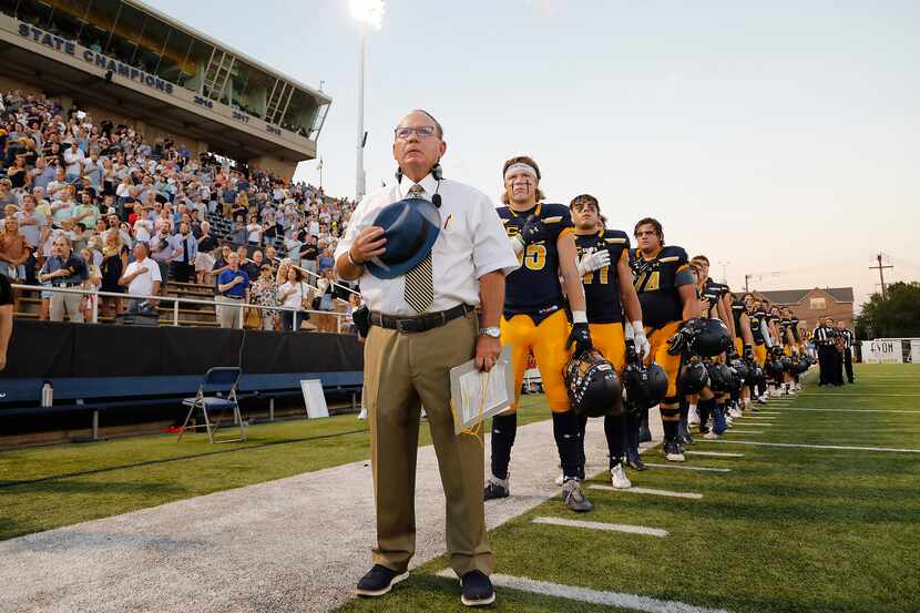 Highland Park High School head coach Randy Allen stands at attention with his team for the...