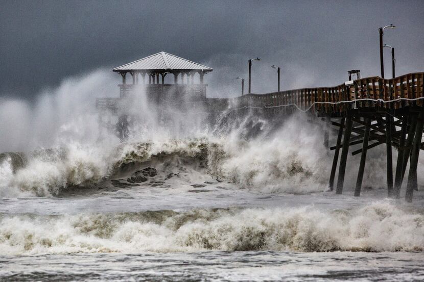 Waves slam the Oceana Pier & Pier House Restaurant in Atlantic Beach, N.C., on Thursday as...