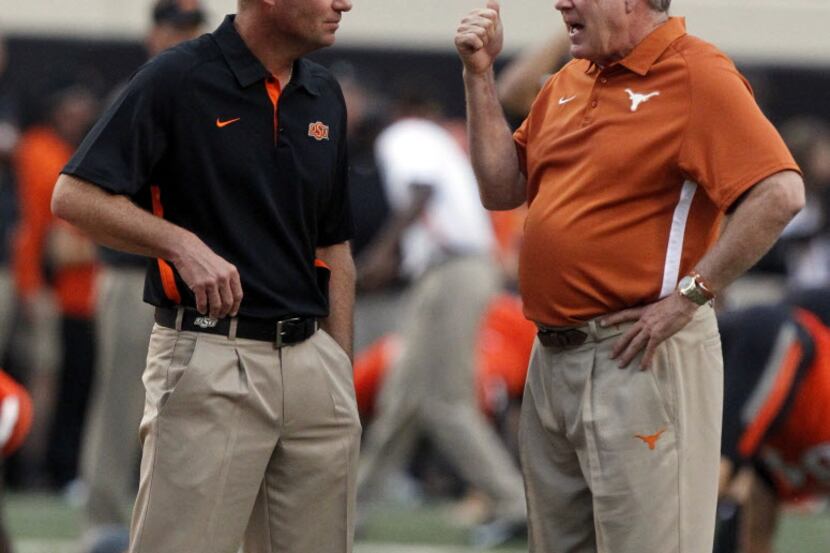 Oklahoma State head coach Mike Gundy listens to Texas head coach Mack Brown prior to their...