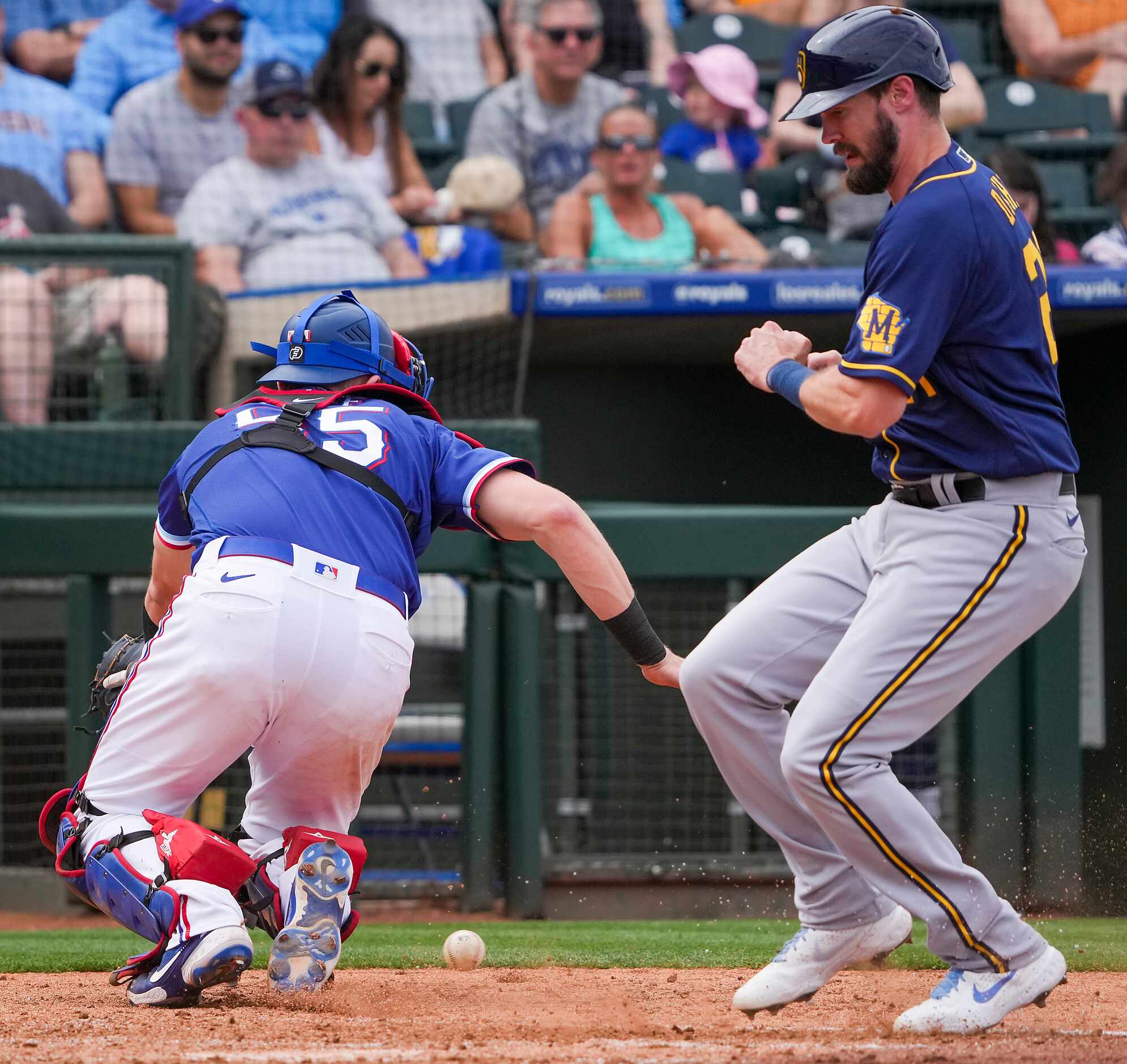 Milwaukee Brewers designated hitter David Dahl scores as the throw gets away from Texas...