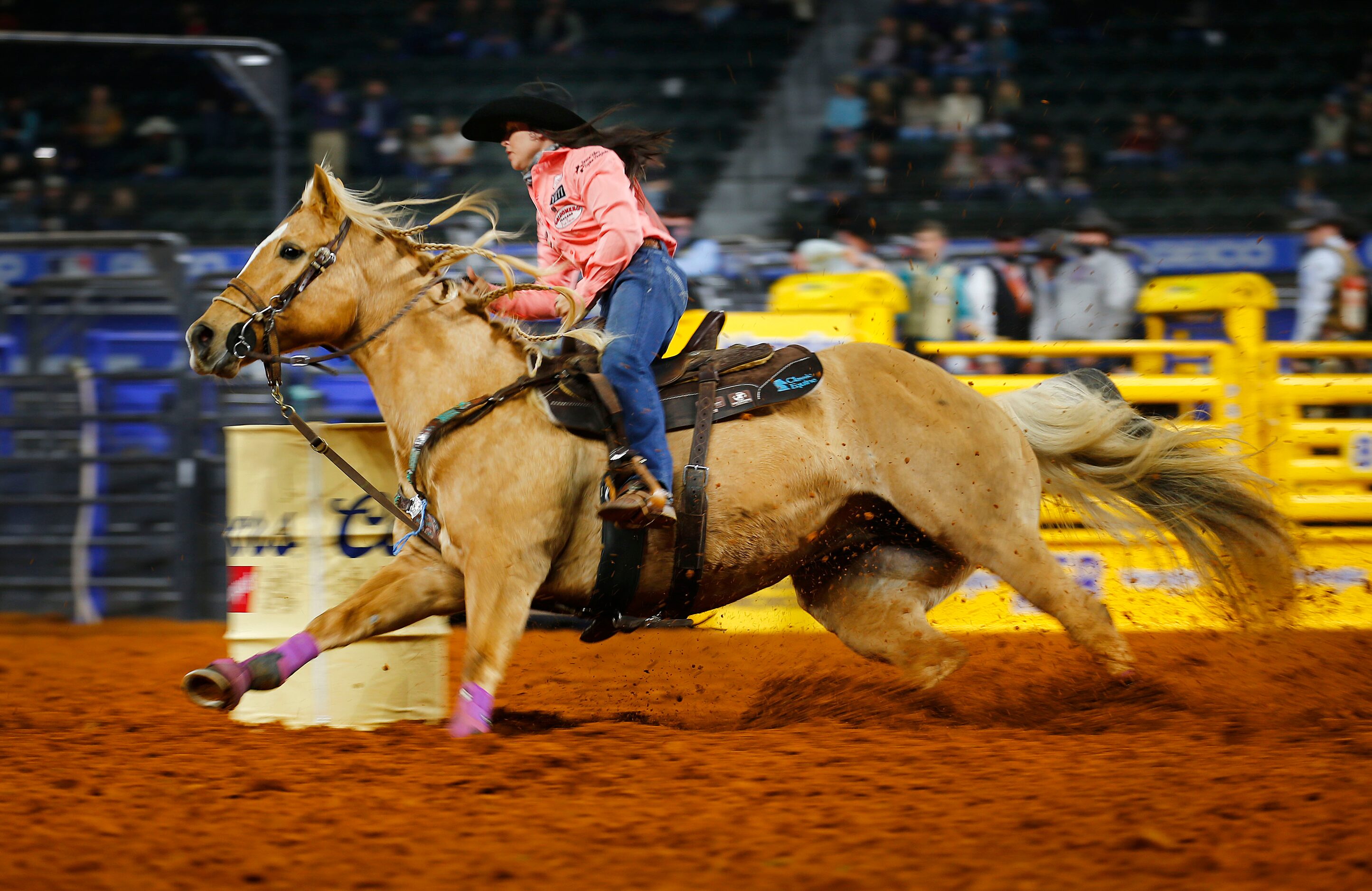 Barrel Racer World Champion Hailey Kinsel of Cotulla, Texas dives into a turn on her horse...