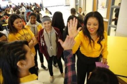  John B. Hood Middle School principal LaTonya Lockhart (right) gives high-fives to her...