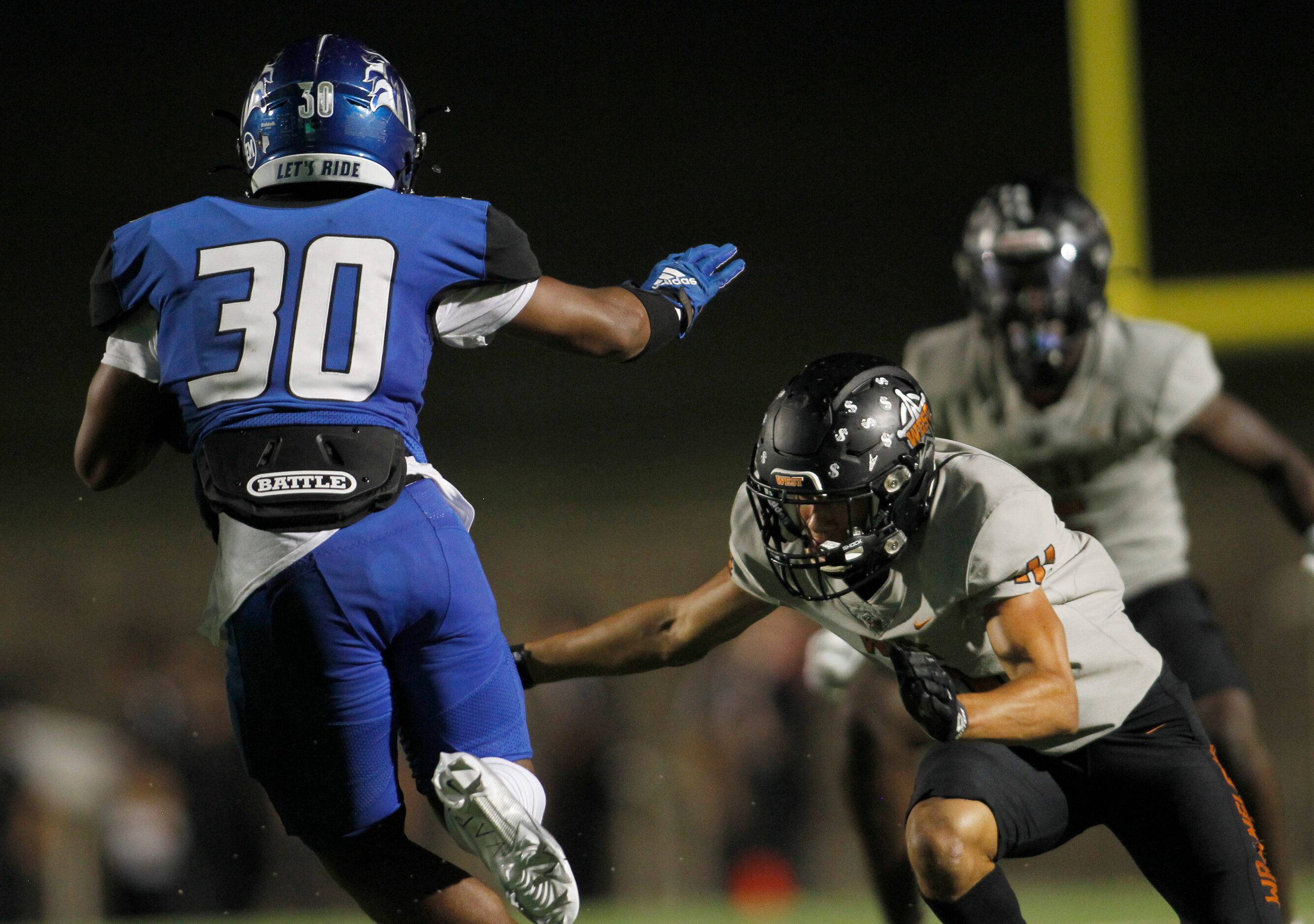 North Mesquite running back Michael Gibson (30), looks for running room as he is pursued by...