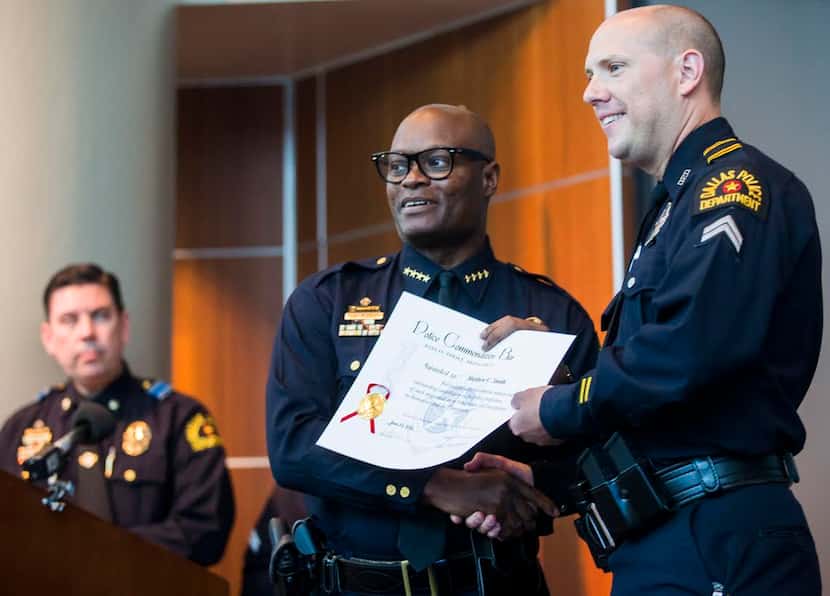  Dallas Police officer Matthew Smith, right, receives a commendation award from Dallas...