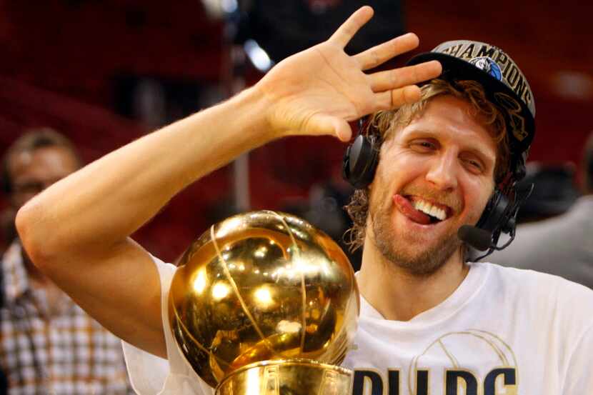 Dallas Mavericks power forward Dirk Nowitzki (41) shows how he drinks his champagne with his...