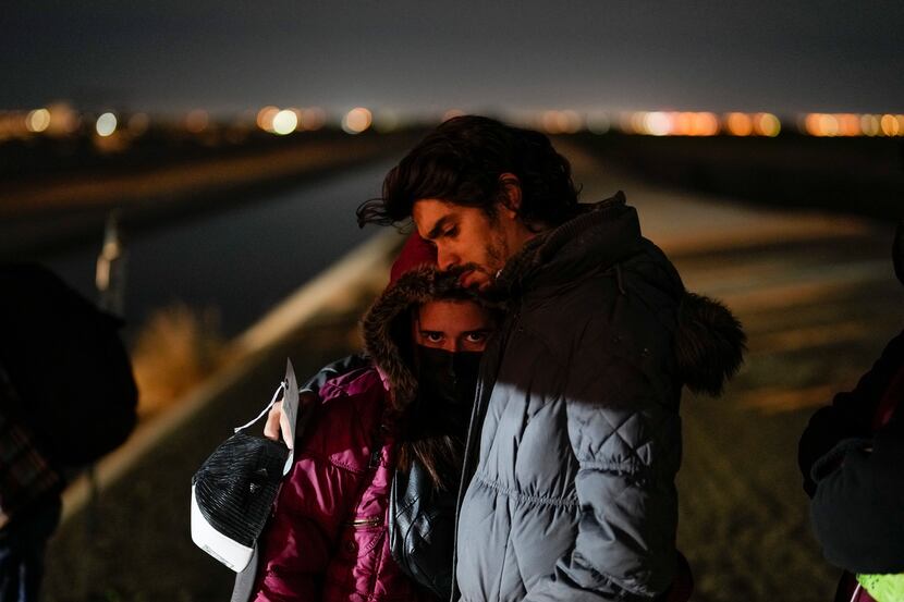 FILE - Cuban migrant Mario Perez holds his wife as they wait to be processed to seek asylum...
