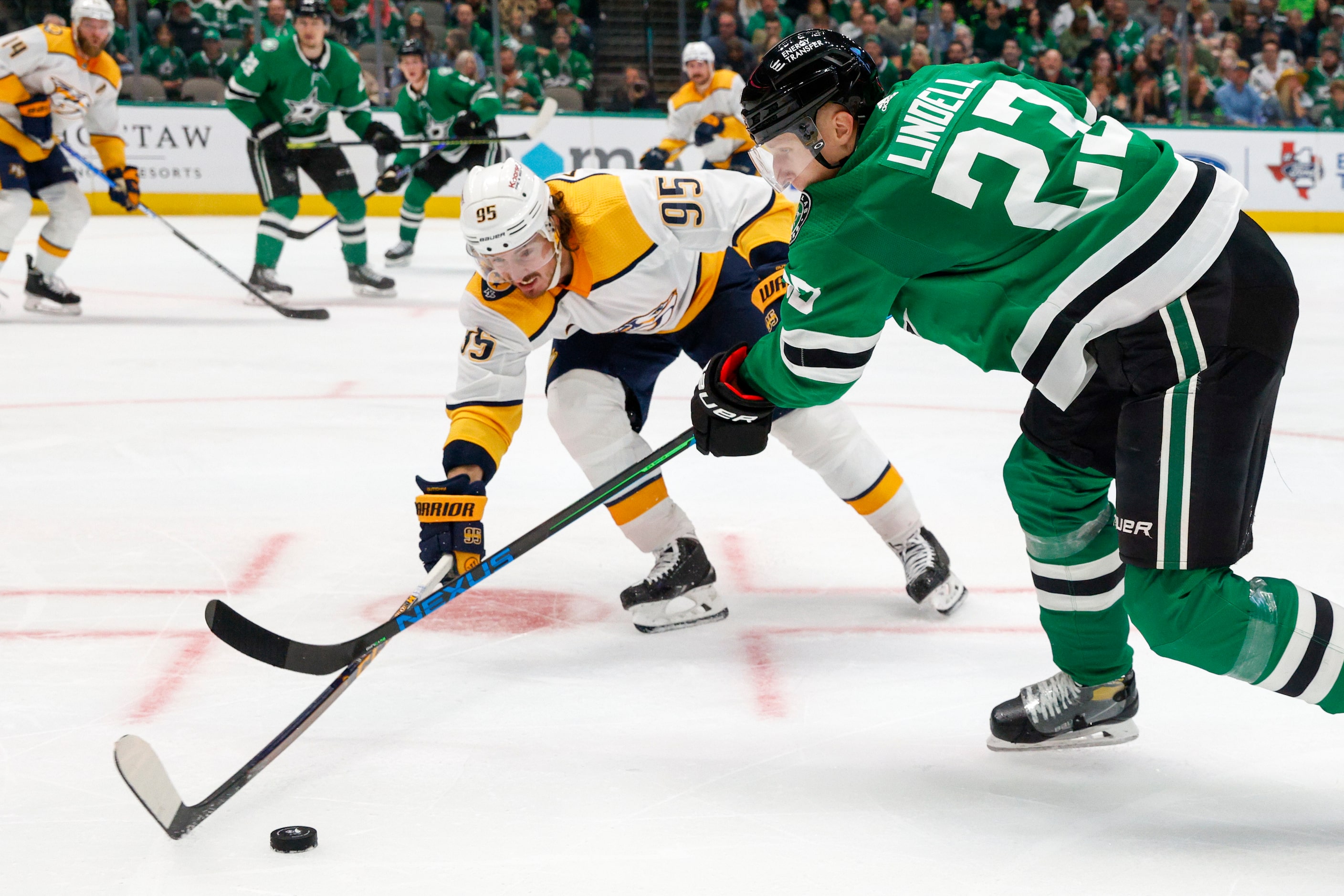 Dallas Stars defenseman Esa Lindell (23) tries to pass the puck around Nashville Predators...