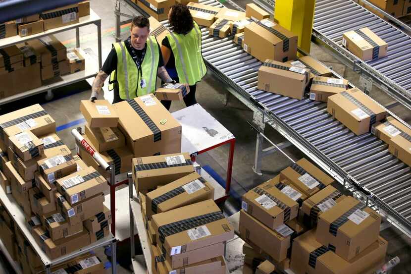 FILE - In this Monday, Dec. 2, 2013, file photo, Amazon.com employees organize outbound...