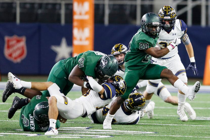 Kennedale's DJ Kirven (28) gets a block from teammates Chris Serwanga (54) and Evan Jowers...